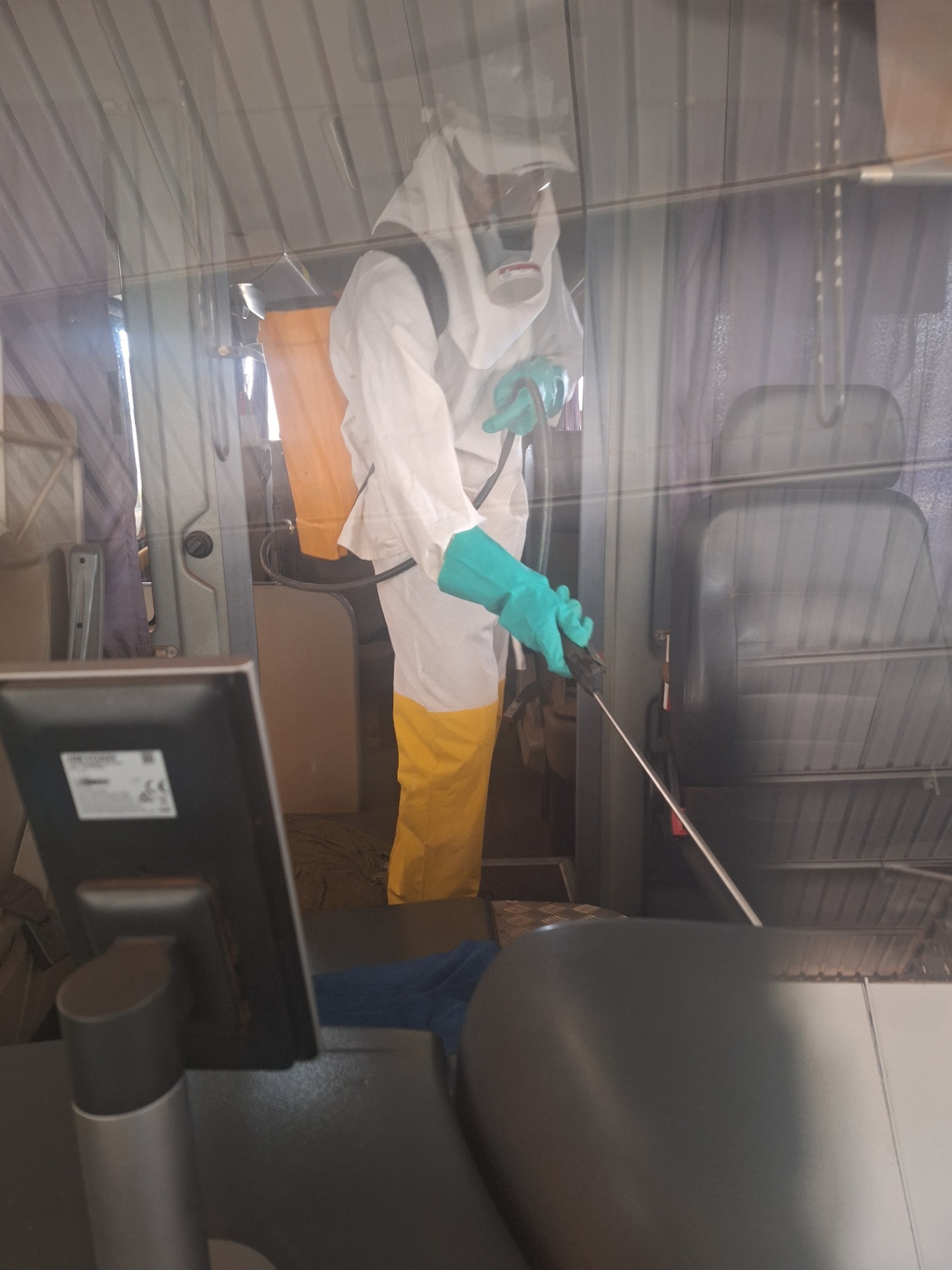 Técnico realizando sanitização no interior de van